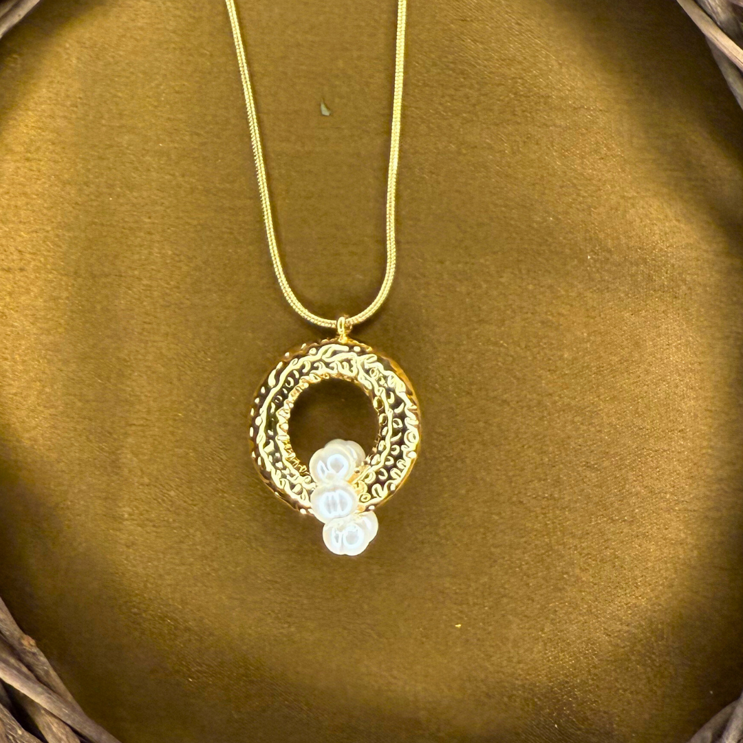 Oceara - A golden swirl cradling a pearl inspired by tides and eternal cycles of renewal.